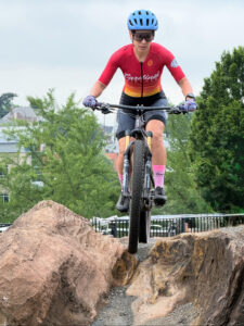 Reference photo for Take Flight: a mountain biker in a red jersey riding off a boulder at Elmwood Park in Roanoke, Virginia