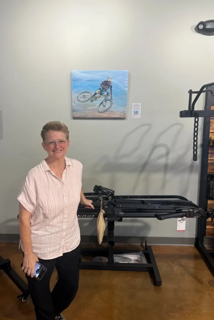 Kristi Gray standing with her mountain bike painting Send It